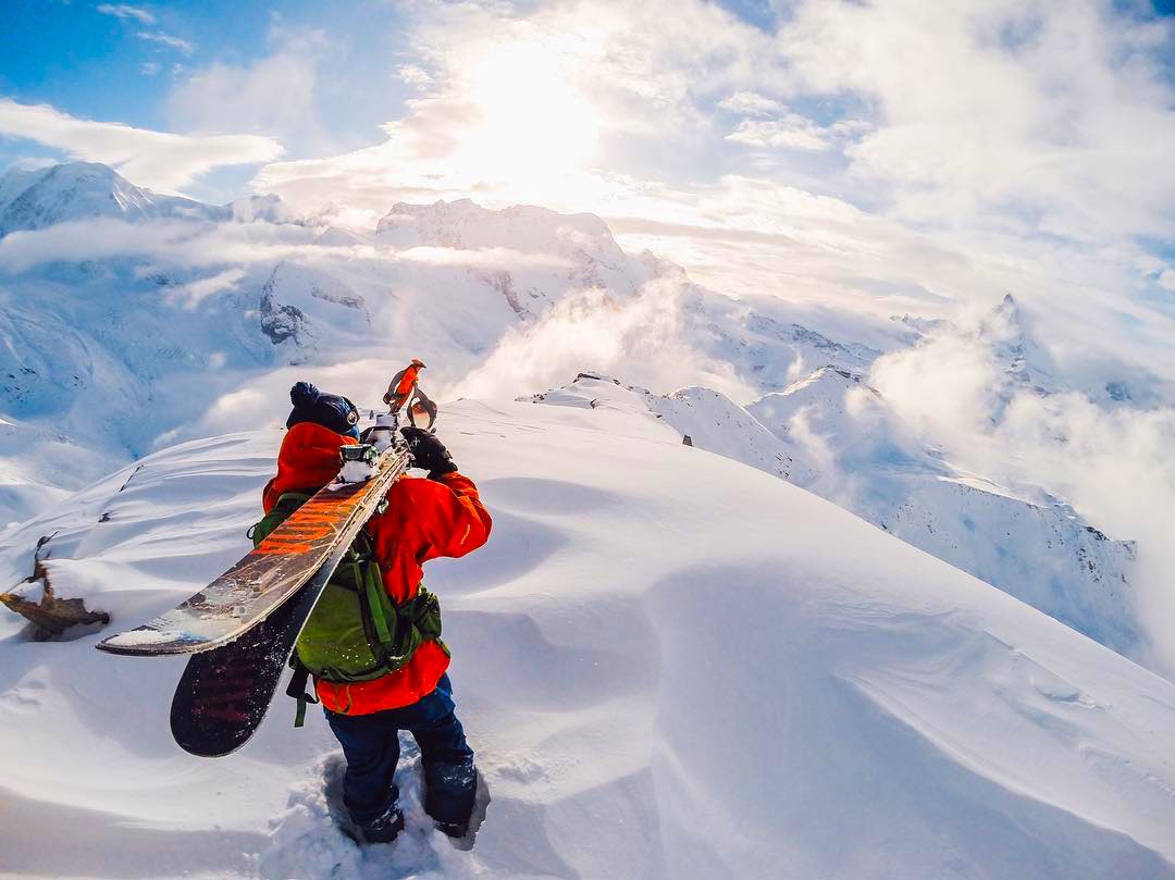Skier carrying skis through the snow-covered Vail Resorts mountains